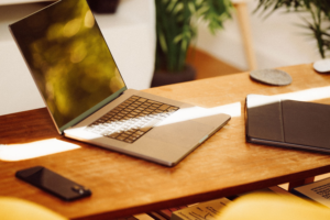 Portfolio A cozy home office setup with a laptop, smartphone, and tablet on a wooden desk indoors.