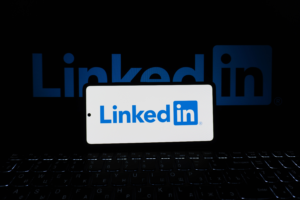 Portfolio Smartphone showing LinkedIn logo with keyboard and large background logo, business theme.